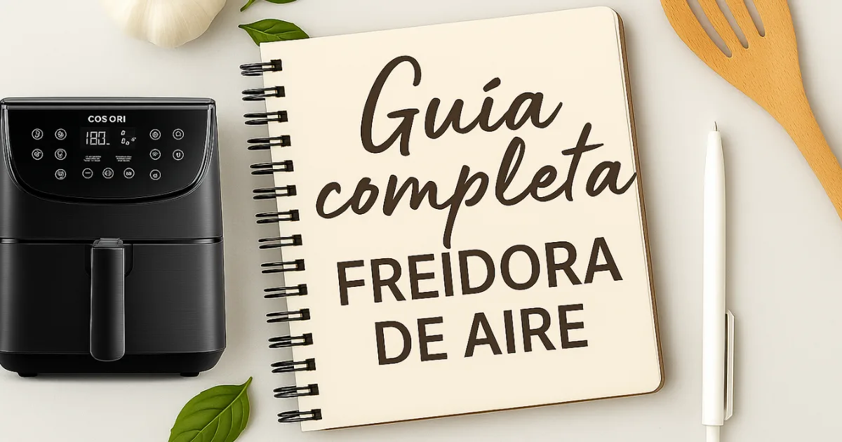 Imagen con una freidora de aire, un cuaderno con el título "Guía completa freidora de aire" y utensilios de cocina sobre fondo claro. Representa una guía práctica para aprender a u
